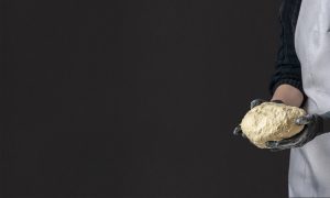 Un pizzaïolo expérimenté prépare à la main la pâte à pizza
