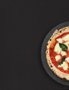 Une pizza napolitaine classique, garnie de tomates fraîches, de mozzarella fondante et de basilic frais, sort d'un four à bois traditionnel. La pâte est dorée et croustillante, et les ingrédients sont de qualité supérieure.